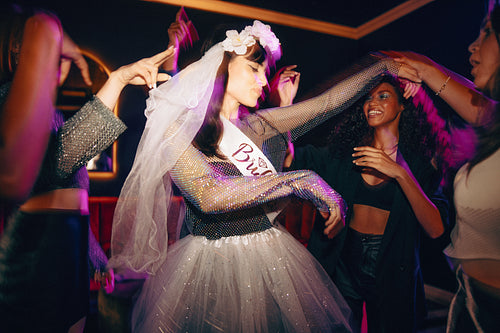 Young women celebrating a bachelorette party with dancing and joy at a nightclub