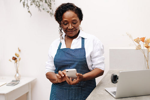 Professional business woman using a mobile phone in her floral shop