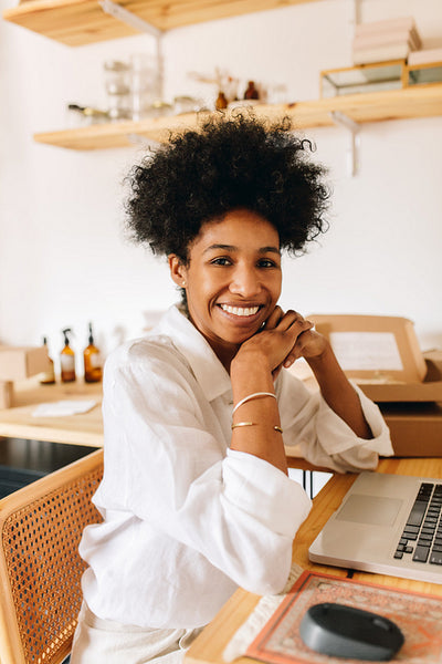 Cheerful e-commerce business owner sitting in office