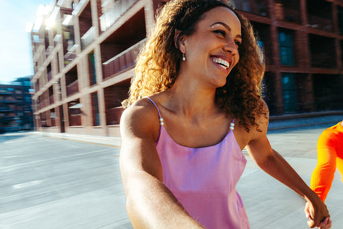 Woman walking outdoors with friend in the city with a cheerful smile