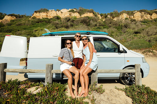 Friends enjoying a summer adventure with a surf van at the beach