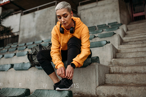 Fitness woman getting ready for workout tying shoe lace