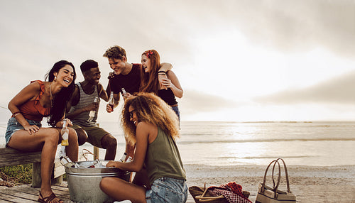 Group of multi-ethnic friends enjoying beers at the beach