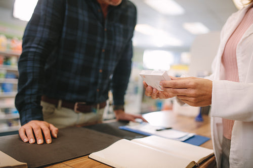 Pharmacist assisting the drug to customer in pharmacy