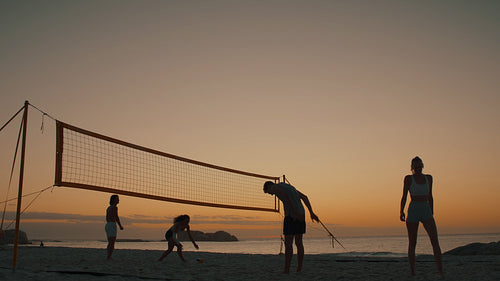 In silhouette: Beach volleyball at sunset