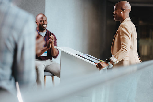 Smiling african american professionals engaging in a cheerful conversation at a modern office reception area