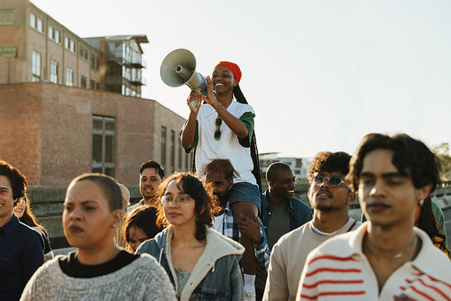 Youth eagerly protesting with a megaphone in a united public gathering