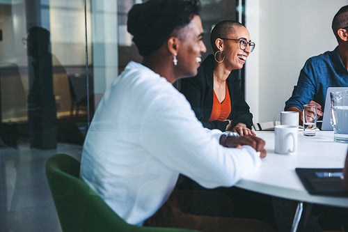Businesspeople smiling during their morning meeting in an office