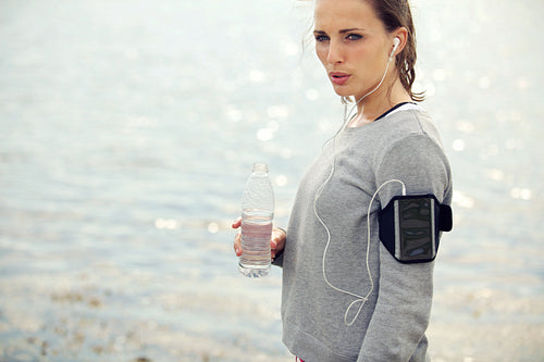 Serious Female Runner Holding Bottled Water