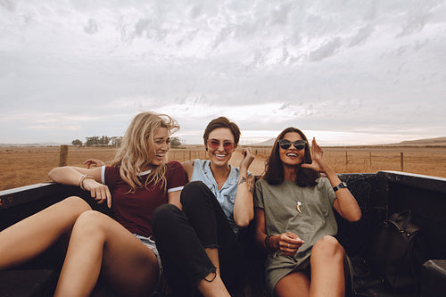Women enjoying a open truck ride on road trip