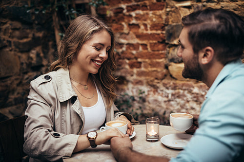 Couple in love holding hands and talking at a restaurant table
