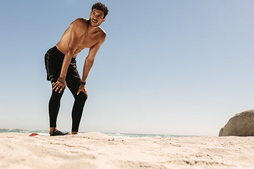 Man relaxing after workout on the beach
