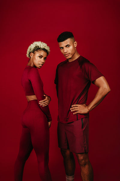 Portrait of fitness couple standing on maroon background