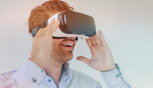 Smiling businessman using virtual reality headset