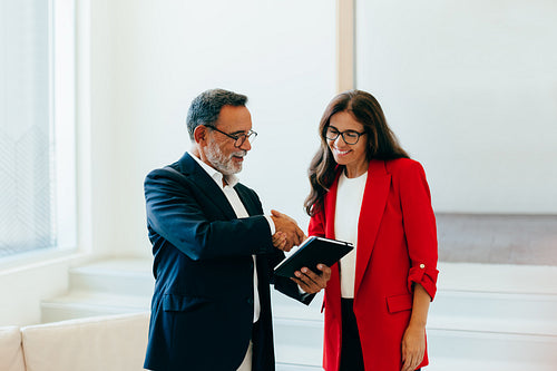 Senior executives discussing business plans using a digital tablet in an office