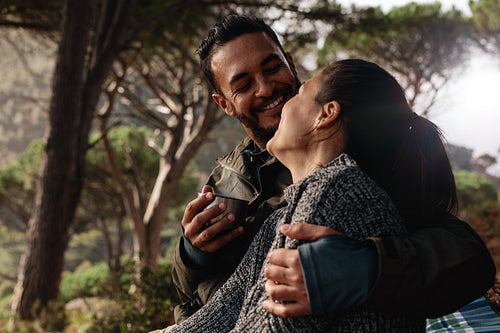 Loving couple camping in forest and having coffee