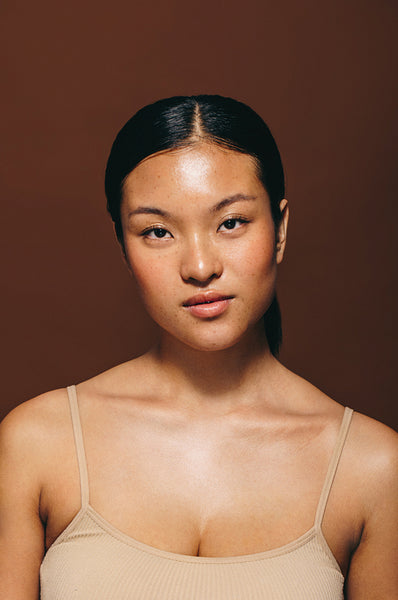 Empowered by skincare, young Asian woman looks at the camera with a confident expression