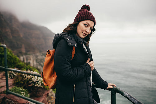 Female tourist standing by a mountain top railing