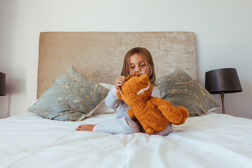 Cute little girl playing with a teddy bear