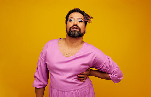 Drag queen posing on yellow background