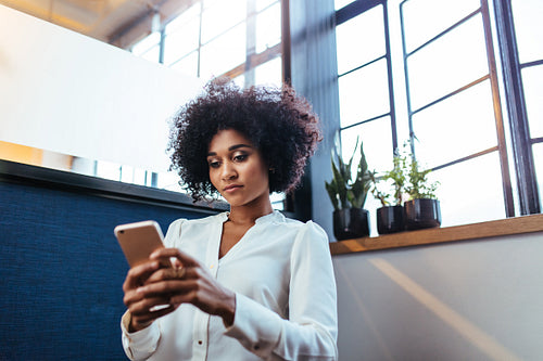 Young businesswoman using smart phone in office