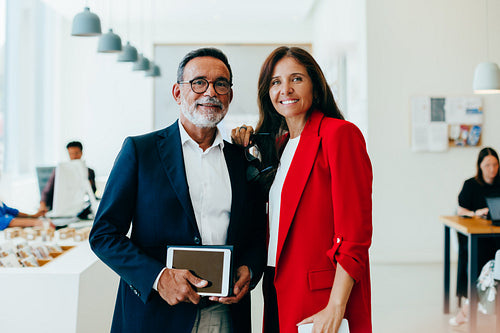 Confident senior professionals in an office setting posing together with smiles