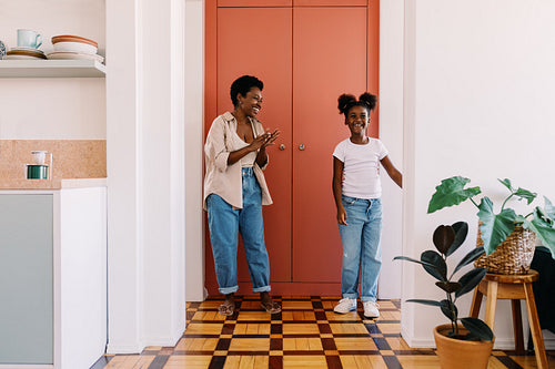 Woman dancing and having fun with her daughter at home