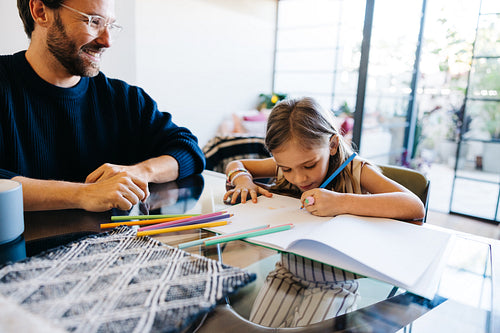 Father and daughter drawing at the table