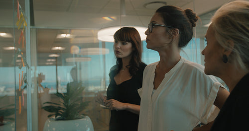 Business team pointing and discussing over sticky notes