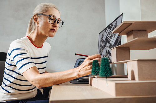 Architect reviewing a scale model design at a modern workspace