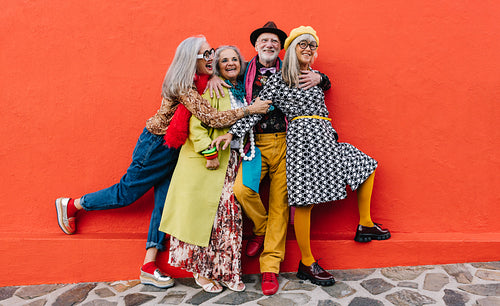Happy senior citizens having fun in colourful clothing