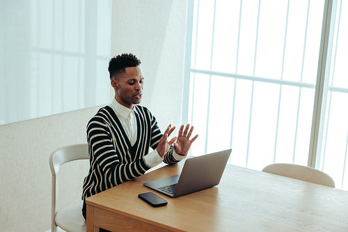 African businessman engaged in a virtual meeting using a laptop computer