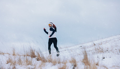 Speed in running sends the woman across snowy winter terrain outdoors