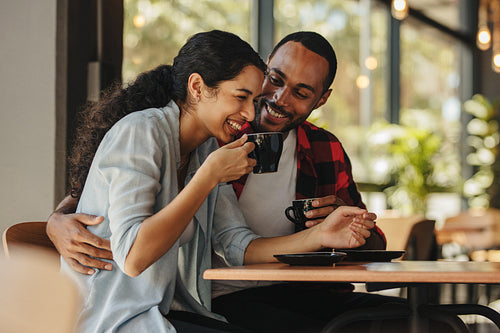 Couple having coffee and smiling in a coffee shop