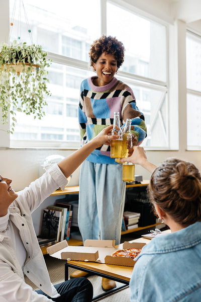 Colleagues toasting drinks in a bright co-working space