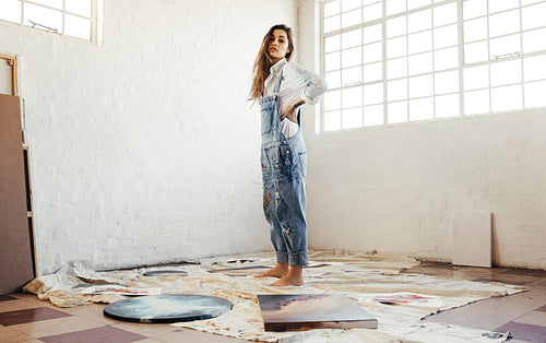 Artist standing in the middle of her paintings