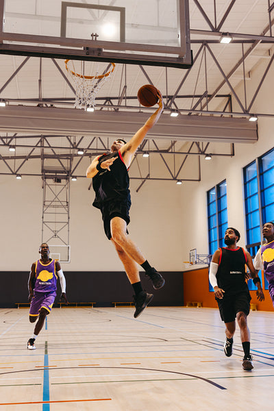 Athletes playing basketball in indoor court