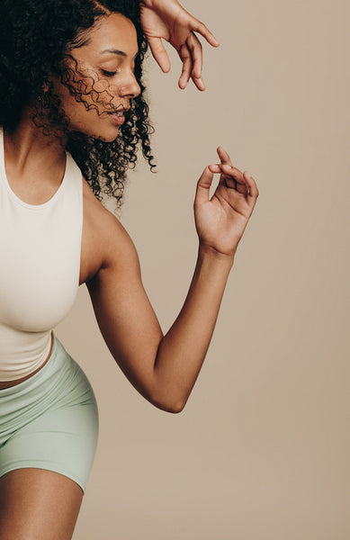Active young woman doing an expressive dance move in a studio