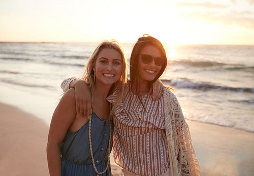 Beautiful young women standing together on the beach