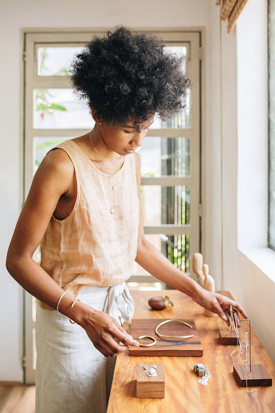 Woman arranging handmade jewelry in studio