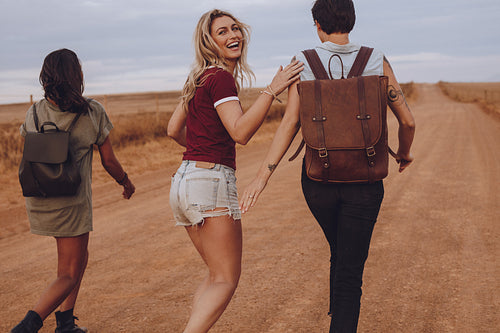 Friends having fun walking on country road