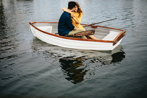 Romantic couple sitting in a boat and kissing