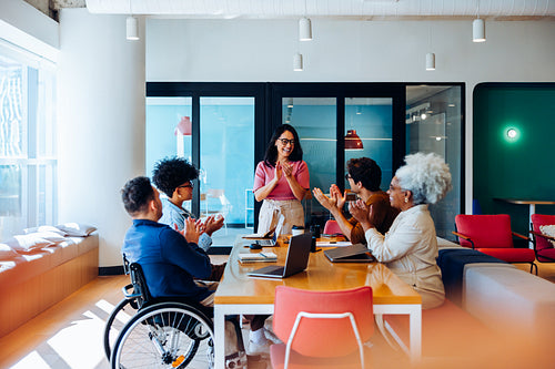 Business team meeting with diverse group applauding