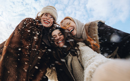 Women take a selfie together outdoors in winter
