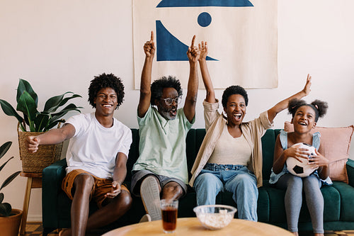 Enjoying Brazilian football: Family celebrating their team's victory at home