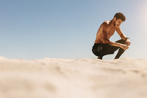Man relaxing after workout on the beach
