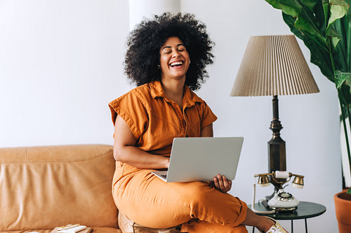 Black businesswoman laughing happily in an office lobby