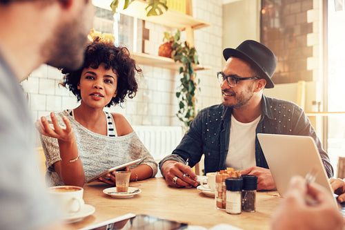 Young woman talking with friends at a cafe