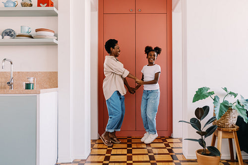Mom and daughter enjoying a fun dance at home