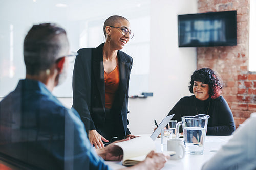 Happy young businesswoman leading a briefing in an office